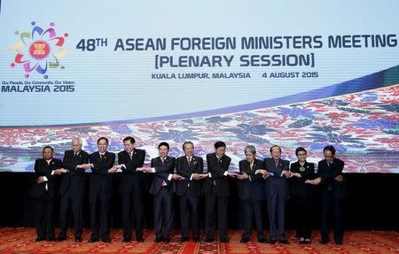 (L-R) Myanmar's Foreign Minister Wunna Maung Lwin, Philippines' Foreign Secretary Albert del Rosario, Singapore's Foreign Affairs Permanent Secretary Chee Wee Kiong, Thailand's Foreign Minister Tanasak Patimapragorn, Vietnam's Foreign Minister Pham Binh Minh, Malaysia's Foreign Minister Anifah Aman, Laos' Foreign Minister Thongloun Sisoulith, Brunei's Foreign Minister Mohamed Bolkiah, Cambodia's Foreign Minister Hor Namhong, Indonesia's Foreign Minister Retno Marsudi and Association of Southeast Asian Nations (ASEAN) Secretary General Le Luong Minh pose for photographs at the 48th ASEAN foreign ministers meeting in Kuala Lumpur, Malaysia, August 4, 2015. REUTERS/Olivia Harris