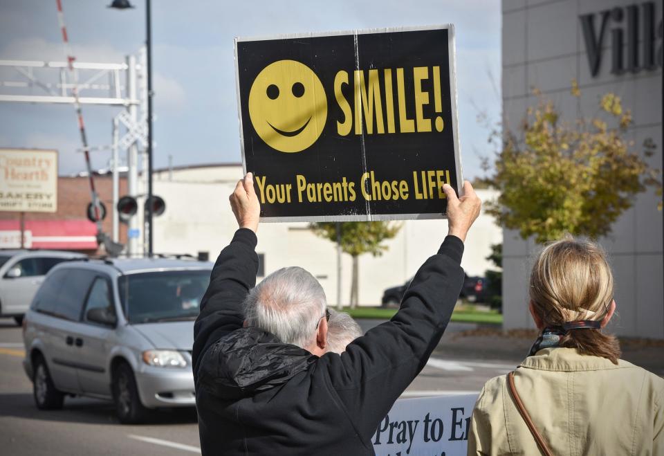 People hold signs Friday, Oct. 14, in front of the St. Cloud Planned Parenthood office on East St. Germain Street as part of the UNITED 40 Days for Life bus tour. 