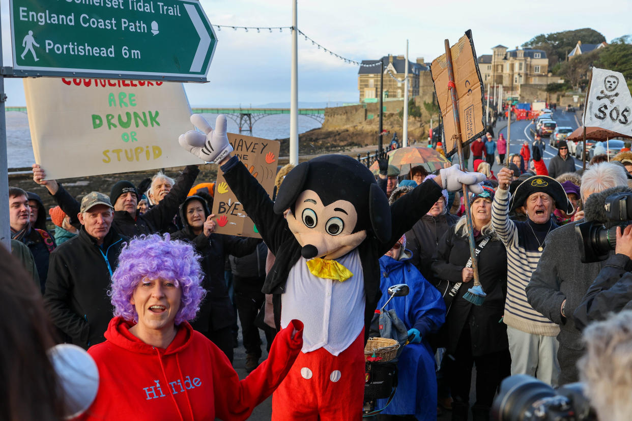 Campaigners Save Our Seafront protest against â€˜wiggly linesâ€™ which have been painted on a road in Clevedon as part of a new layout.
The protest to called â€˜Snake on Sundayâ€™ where demonstrators in fancy dress with homemade banners are â€˜walking the lineâ€™ in a wavy wiggle conga. Members believe the wiggly changes to the Victorian seafront amount to 'vandalism' by the council. Protesters will demand the road is put back to how it was. 15/01/2023