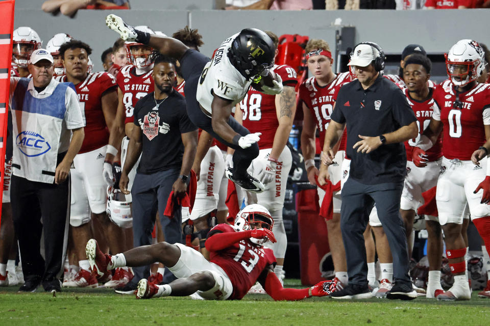 Wake Forest's Justice Ellison (6) hurdles the tackle of North Carolina State's Tyler Baker-Williams (13) during the first half of an NCAA college football game in Raleigh, N.C., Saturday, Nov. 5, 2022. (AP Photo/Karl B DeBlaker)