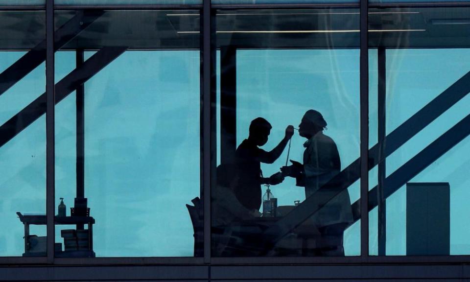 Temperatures are taken at a control point on a footbridge at the Dell Deton medical center in Austin, Texas, on 25 March.