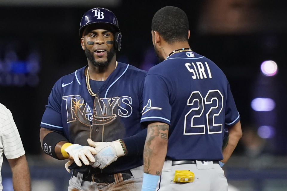 Tampa Bay Rays' Jose Siri (22) checks on Yandy Diaz after Diaz hurt his fingers while sliding into second base during the fifth inning of a baseball game, Tuesday, Aug. 30, 2022, in Miami. (AP Photo/Marta Lavandier)