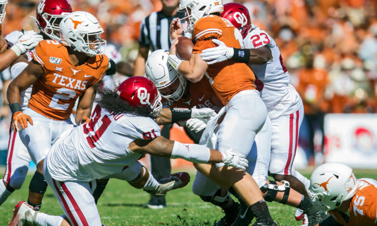 Sam Ehlinger tackled by several Oklahoma Sooners.