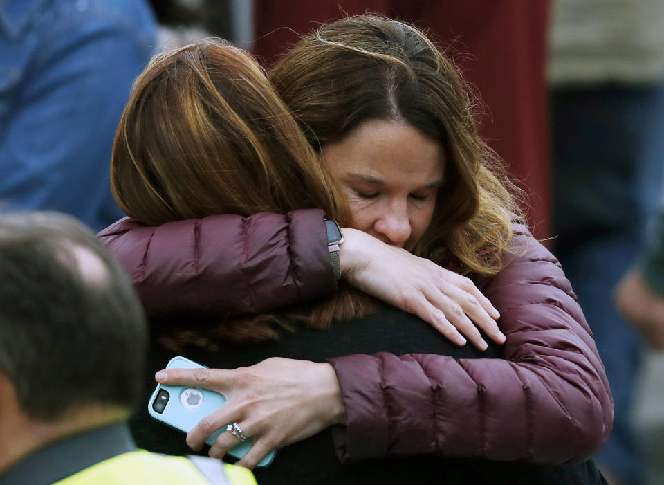 Parents hug as they wait for their children. Source: AAP