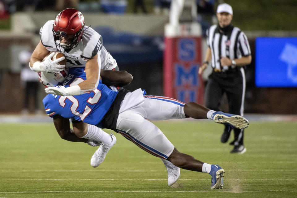 Cincinnati tight end Josh Whyle is taken down by SMU defensive back Brandon Stephens (23) during the first half of an NCAA college football game Saturday, Oct. 24, 2020, in Dallas. (AP Photo/Jeffrey McWhorter)