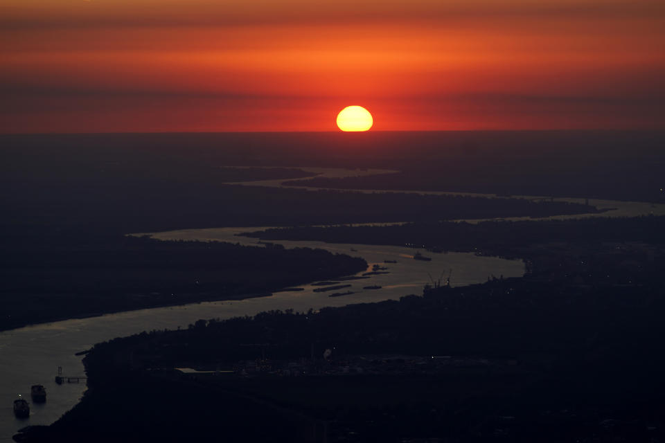 Ships travel along the Mississippi River in LaPlace, La., as the sun sets on Friday, Oct. 20, 2023. (AP Photo/Gerald Herbert)