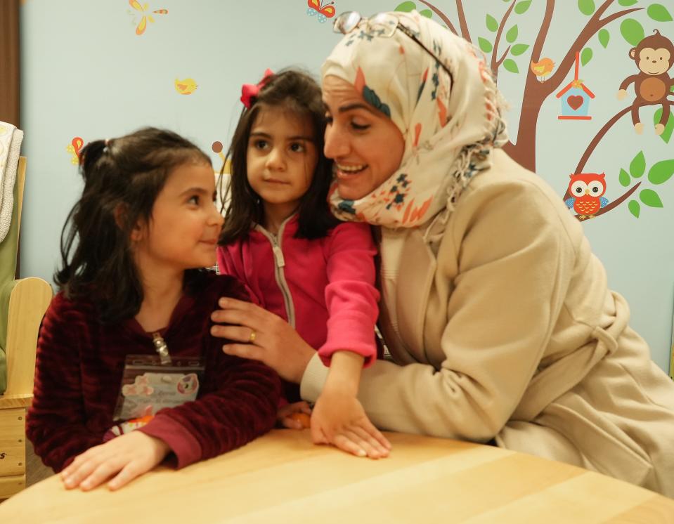 Afra Almasre checks in with two of her four children, Zena, 5, and Haya, 3, after classes at a three-generation English as a Second Language program run by Festa, a local nonprofit group. Afra attends classes twice each week fort three hours (total of six hours per week), while the kids receive English language immersion and academic enrichment programming, and are served a nutritious dinner.