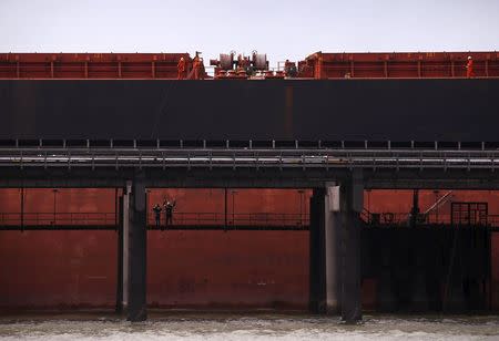 Port workers load a ship with coal at the RG Tanna Coal Terminal located at the town of Gladstone in Queensland, Australia, June 12, 2015. REUTERS/David Gray