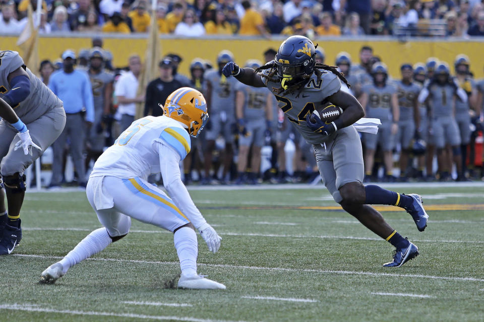 West Virginia running back Tony Mathis Jr. (24) is defended by Long Island safety Derrick Edafe during the first half of an NCAA college football game in Morgantown, W.Va., Saturday, Sept., 11, 2021. (AP Photo/Kathleen Batten)