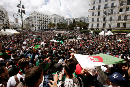 People carry national flags during a protest against the appointment of interim president, Abdelkader Bensalah demanding radical changes to the political system in Algiers, Algeria April 10, 2019. REUTERS/Ramzi Boudina