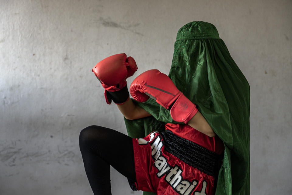 An Afghan woman who practices Muay Tha, or Thai boxing, poses for a photo in Kabul, Afghanistan, Saturday, Oct. 29, 2022. The ruling Taliban have banned women from sports as well as barring them from most schooling and many realms of work. A number of women posed for an AP photographer for portraits with the equipment of the sports they loved. Though they do not necessarily wear the burqa in regular life, they chose to hide their identities with their burqas because they fear Taliban reprisals and because some of them continue to practice their sports in secret. (AP Photo/Ebrahim Noroozi)