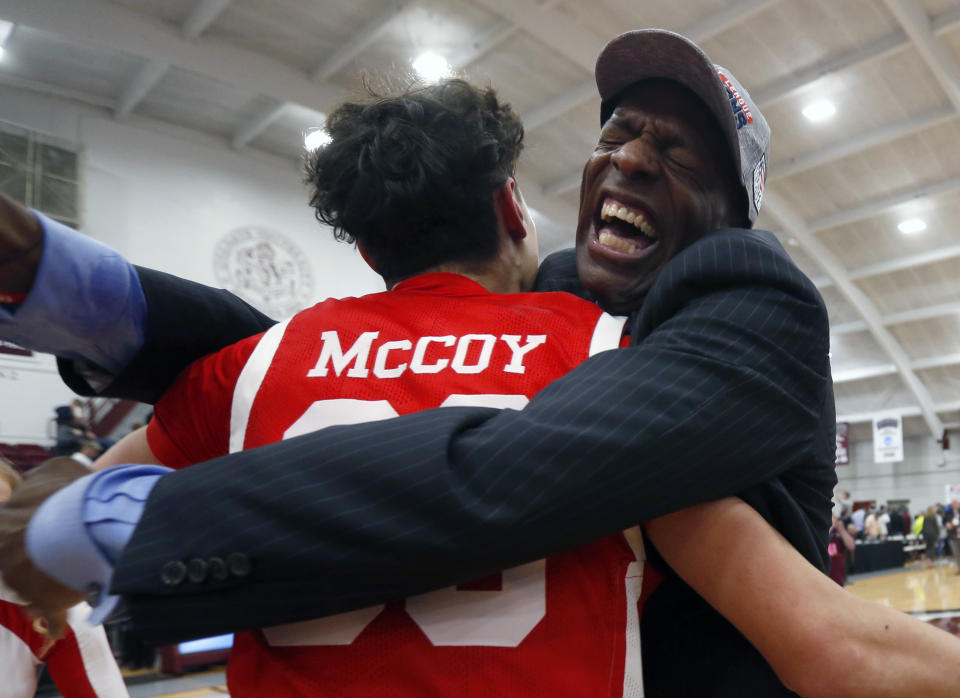 Boston University's Javante McCoy celebrates with head coach Joe Jones after winning the NCAA Patriot League Conference basketball championship over Colgate at Cotterell Court, Wednesday, March 11, 2020, in Hamilton, N.Y. (AP Photo/John Munson)