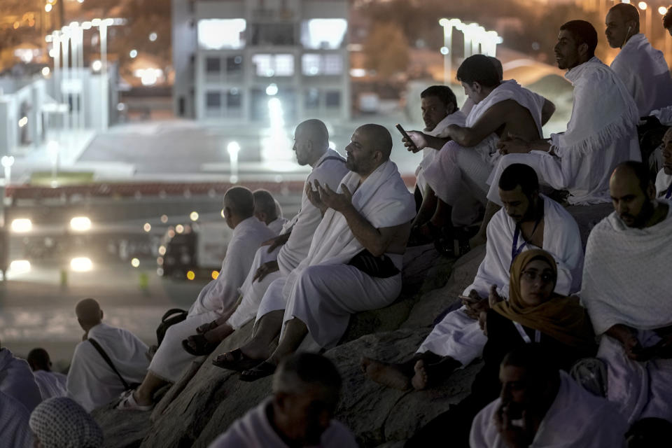 Muslim pilgrims pray on the rocky hill known as the Mountain of Mercy, on the Plain of Arafat, during the annual Hajj pilgrimage, near the holy city of Mecca, Saudi Arabia, Tuesday, June 27, 2023. Around two million pilgrims are converging on Saudi Arabia's holy city of Mecca for the largest Hajj since the coronavirus pandemic severely curtailed access to one of Islam's five pillars. (AP Photo/Amr Nabil)