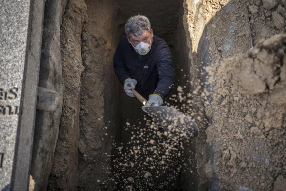 SPAIN: An undertaker prepares a grave at the Almudena cemetery in Madrid.