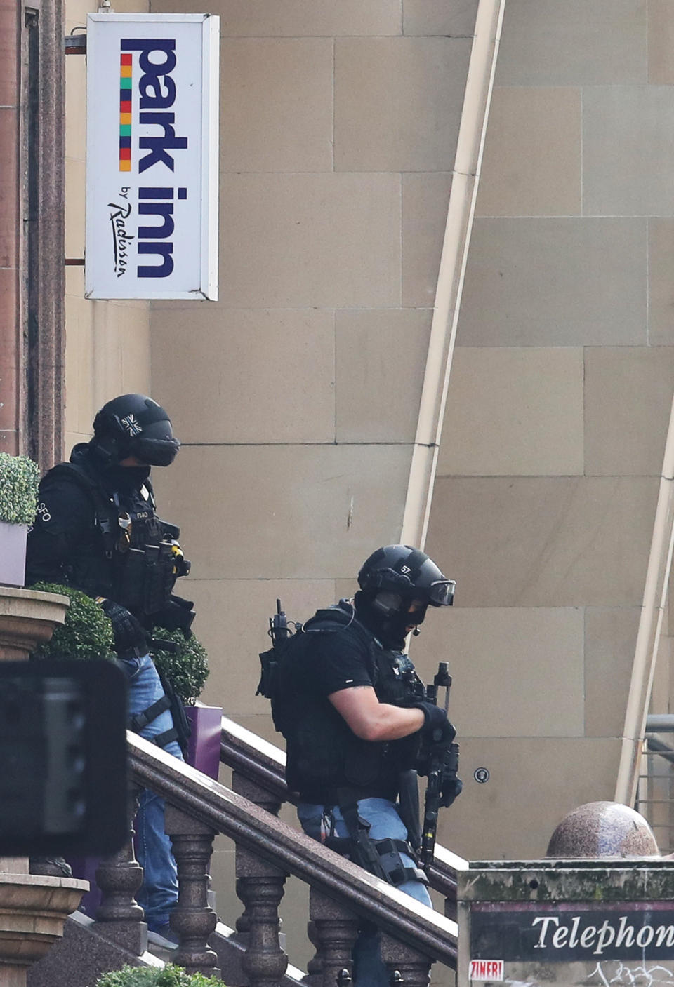 Armed police officers leave the Park Inn hotel in West George Street, Glasgow, after a suspect male was shot by an armed officer. (PA)