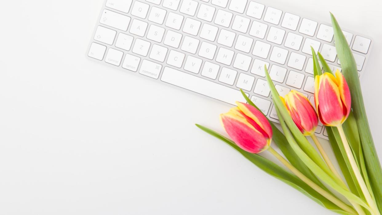  Tulips next to computer keyboard. 