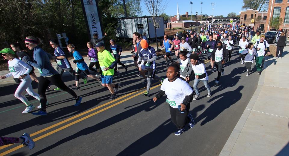 People take part in the start of the Gaston Community Foundation 5K Run early Saturday morning, April 9, 2022, outside CaroMont Health Park.