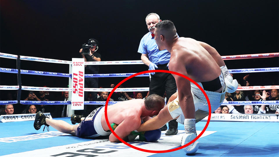 Paul Gallen (pictured left) wraps his hands around the legs of Justis Huni (pictured right) and tackles him.