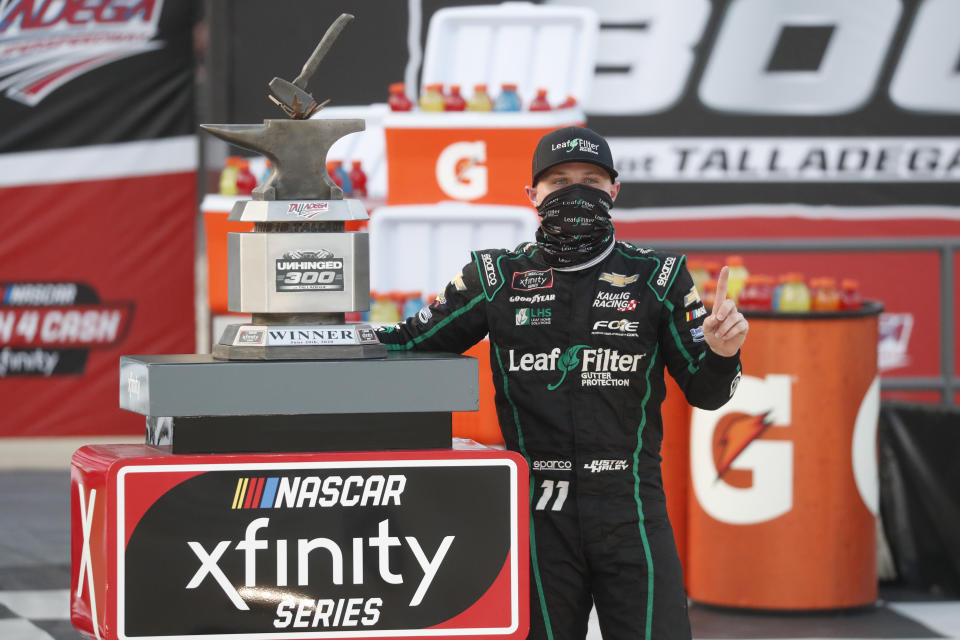 Justin Haley celebrates with the winner's trophy in Victory Lane after winning a NASCAR Xfinity auto race at Talladega Superspeedway in Talladega Ala., Saturday, June 20, 2020. (AP Photo/John Bazemore)