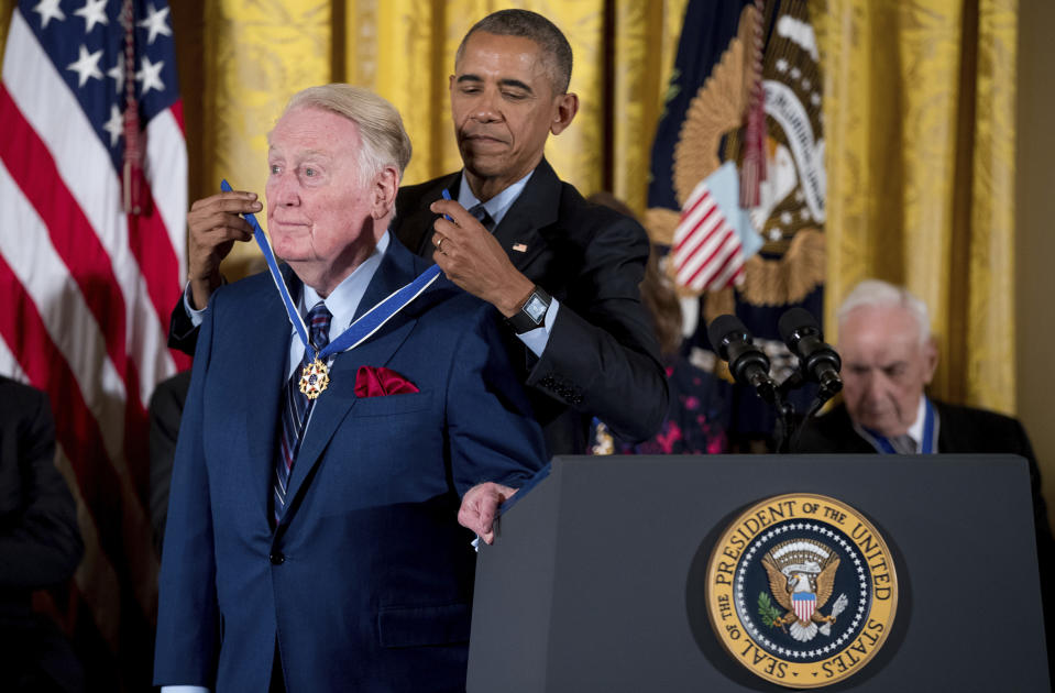 FILE - President Barack Obama presents the Presidential Medal of Freedom to former Los Angeles Dodgers broadcaster Vin Scully in the East Room of the White House in Washington on Nov. 22, 2016. Scully, whose dulcet tones provided the soundtrack of summer while entertaining and informing Dodgers fans in Brooklyn and Los Angeles for 67 years, died Tuesday night, Aug. 2, 2022, the team said. He was 94. (AP Photo/Andrew Harnik, File)