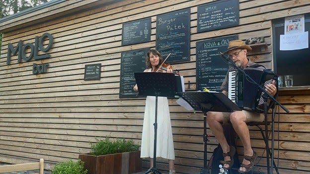 Lucie (at left) and Jim Carlson, who make up the musical duo Cricket and Snail, perform at MoLo Bar in Prague.