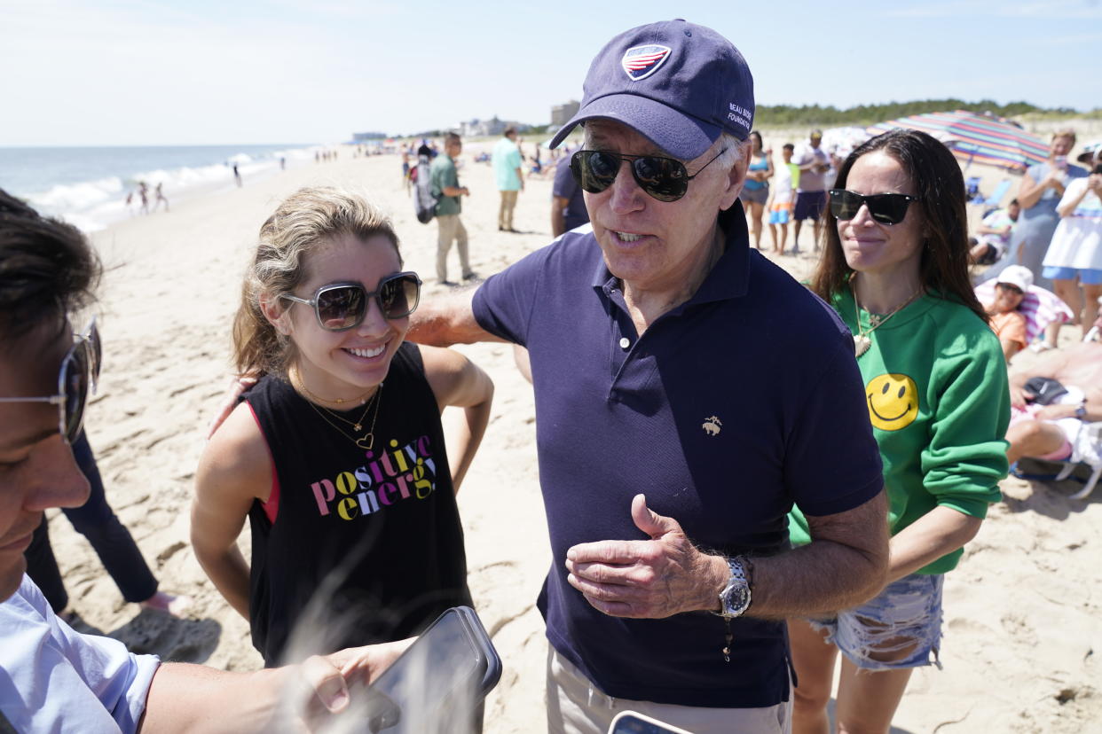 President Joe Biden talks to the media after walking on the beach with his granddaughter Natalie Biden, left, and his daughter Ashley Biden, right, Monday, June 20, 2022 at Rehoboth Beach, Del. (AP Photo/Manuel Balce Ceneta)