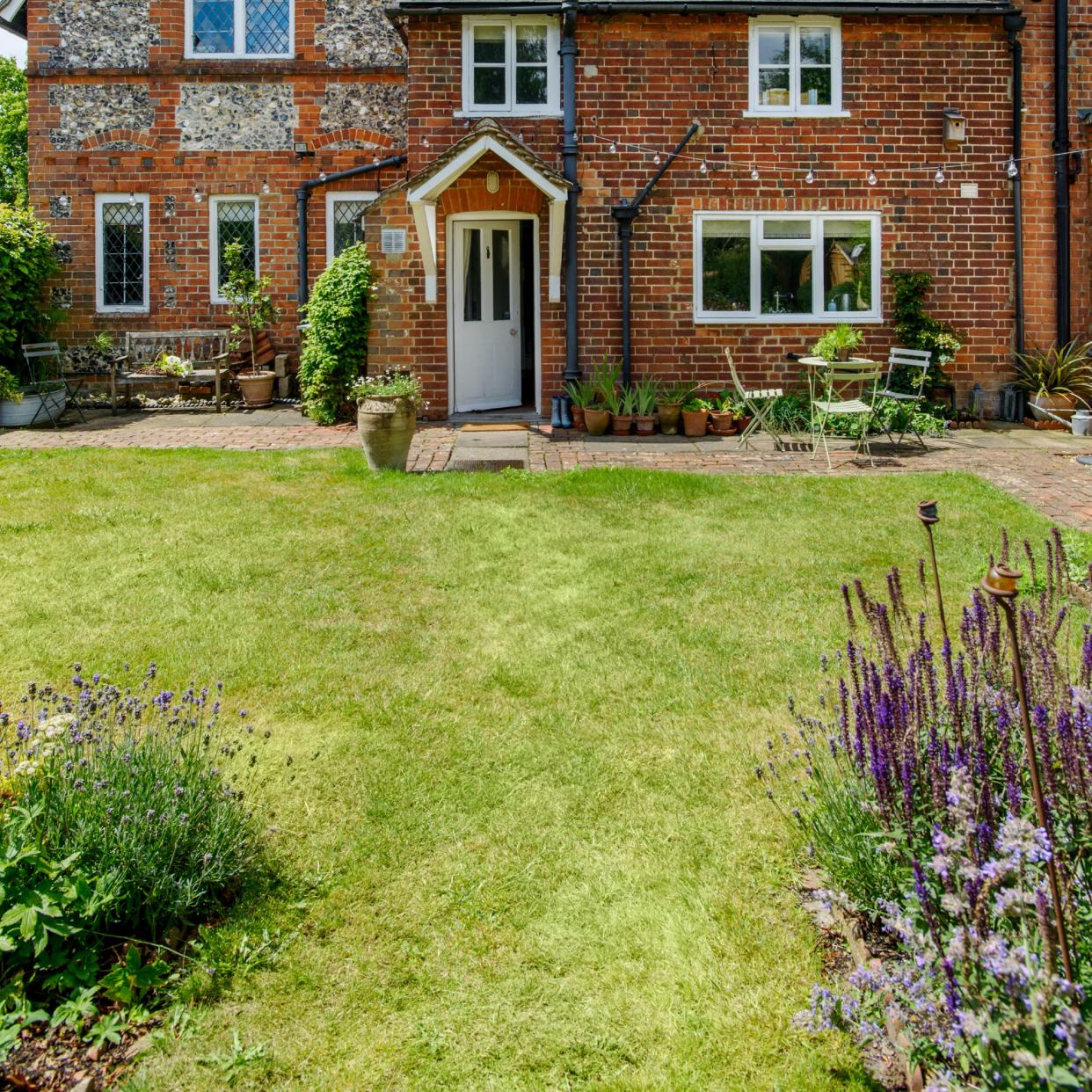  A lawn with a red brick house in the background. 