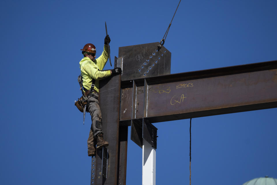 An ironworker guides a beam during construction of a municipal building in Norristown, Pa., Wednesday, Feb. 15, 2023. A strong job market has helped fuel the inflation pressures that have led the Federal Reserve to keep raising interest rates. (AP Photo/Matt Rourke)