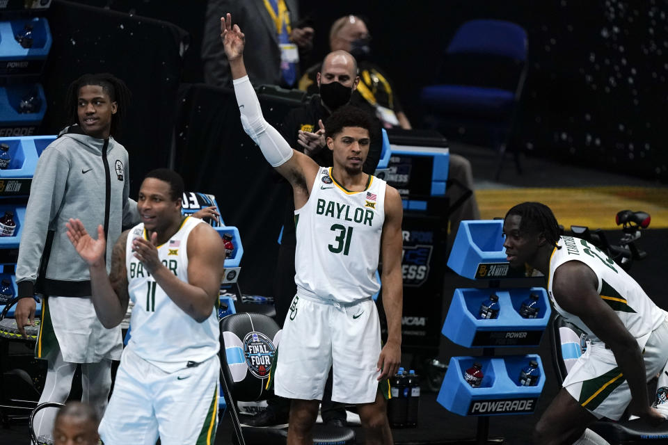 Baylor guard Mark Vital (11), MaCio Teague (31) and Jonathan Tchamwa Tchatchoua, right, celebrate on the bench during the first half of a men's Final Four NCAA college basketball tournament semifinal game against Houston, Saturday, April 3, 2021, at Lucas Oil Stadium in Indianapolis. (AP Photo/Michael Conroy)