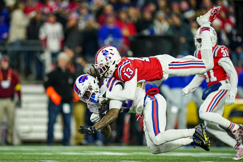 Bills running back James Cook is tackled by Patriots cornerback Jack Jones during a game in December.