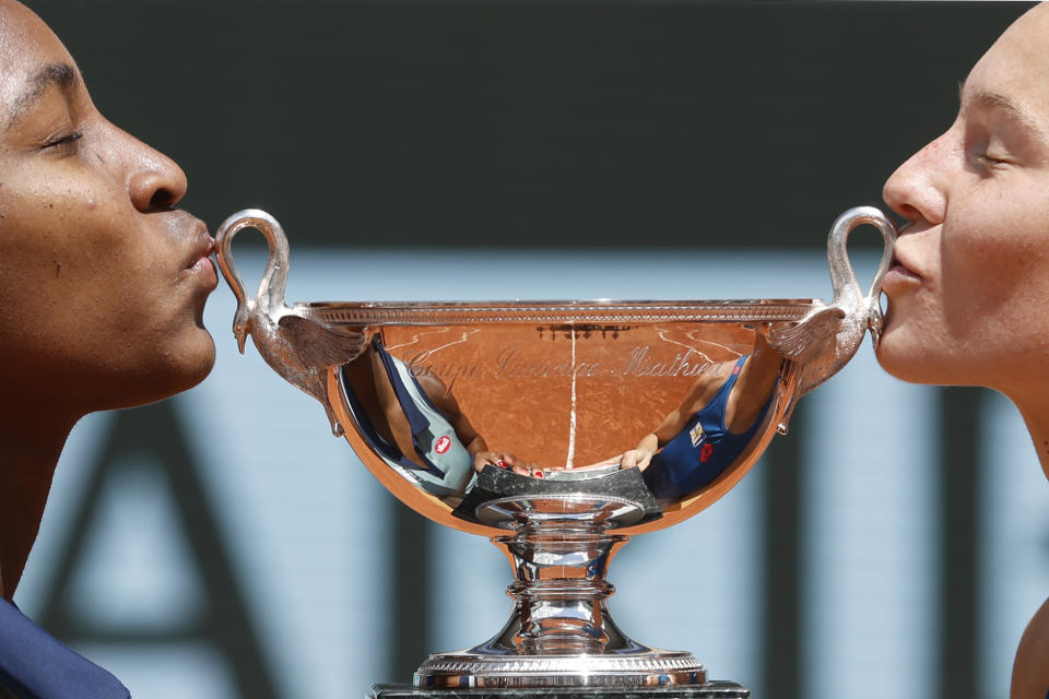 Coco Gauff of the U.S., left, and Katerina Siniakova of the Czech Republic kiss the trophy after they won the women's doubles final match of the French Open tennis tournament against Italy's Sara Errani and Jasmine Paolini at the Roland Garros stadium in Paris, Sunday, June 9, 2024. (AP Photo/Jean-Francois Badias)