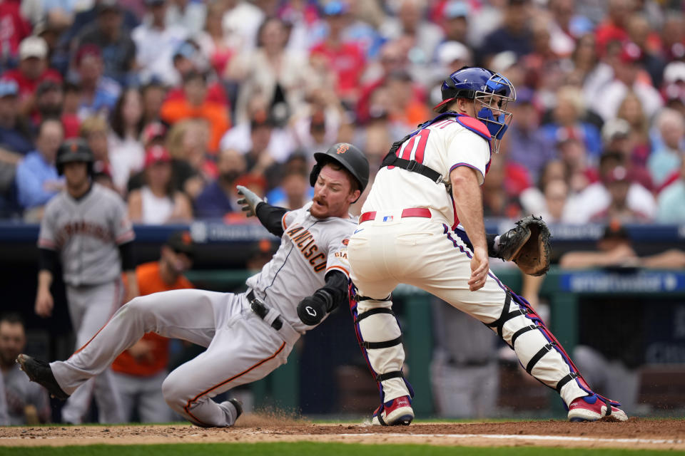 San Francisco Giants' Wade Meckler, left, scores past Philadelphia Phillies catcher J.T. Realmuto on a single by Wilmer Flores during the third inning of a baseball game, Wednesday, Aug. 23, 2023, in Philadelphia. (AP Photo/Matt Slocum)