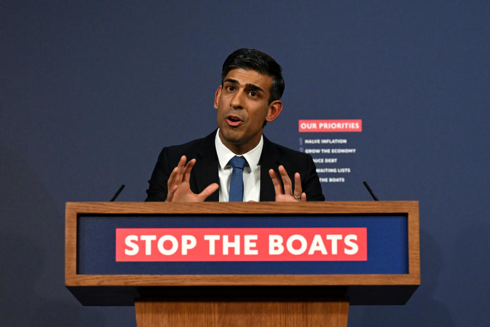 U.K. Prime Minister Rishi Sunak speaks at a lectern emblazoned with the words: Stop the Boats.