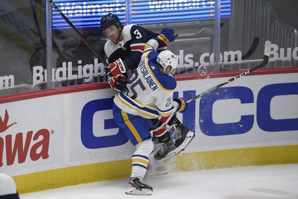 Buffalo Sabres center Arttu Ruotsalainen (25) checks Washington Capitals defenseman Nick Jensen (3) against the boards during the second period of an NHL hockey game Thursday, April 15, 2021, in Washington. (AP Photo/Nick Wass)