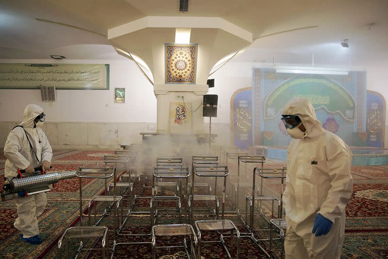 Members of the medical team spray disinfectant to sanitize indoor place of Imam Reza's holy shrine, following the coronavirus outbreak, in Mashhad