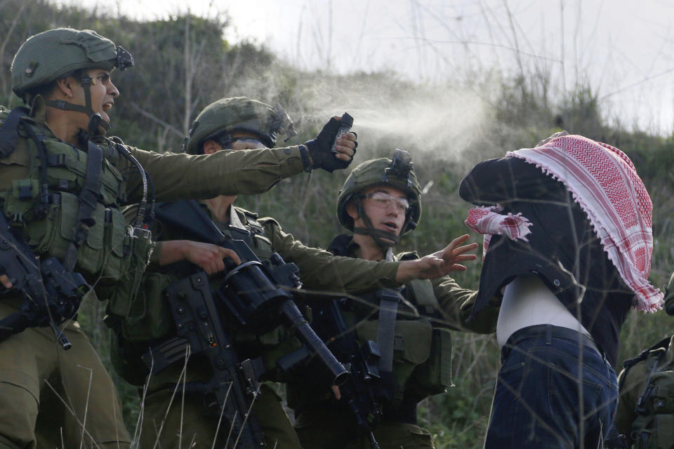 ARCHIVO - Soldados israelíes rocían gas lacrimógeno contra un manifestante palestino cerca del asentamiento judío de Yitzhar, cerca de la ciudad cisjordana de Nablus, el viernes 21 de febrero de 2020. (AP Foto/Majdi Mohammed, archivo)