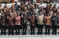 Indonesian President Joko Widodo, front row fourth from left, and his deputy Ma'ruf Amin, fifth from left, wave at the media as they pose for photographers with their new cabinet ministers during the announcement of the new cabinet at Merdeka Palace in Jakarta, Indonesia, Wednesday, Oct. 23, 2019. (AP Photo/Dita Alangkara)