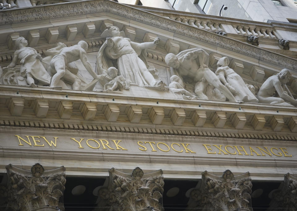 Marble sculptures occupy the pediment above the New York Stock Exchange signage, Tuesday Aug. 25, 2020, in New York. U.S. stocks are drifting close to their record heights Tuesday, as momentum slows on Wall Street.(AP Photo/Bebeto Matthews)