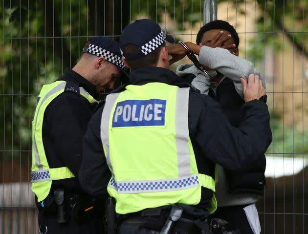 Police officers handcuff a man at the Notting Hill Carnival in west London. 