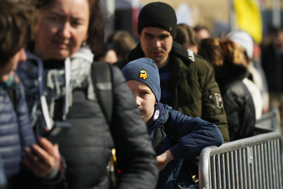 FILE - Refugees wait for transport after fleeing the war from neighbouring Ukraine at the border crossing in Medyka, southeastern Poland, on Saturday, March 26, 2022. Since the invasion of Ukraine more than eight months ago, Poland has aided the neighboring country and millions of its refugees — both to ease their suffering and to help guard against the war spilling into the rest of Europe. But a missile strike that killed two men Tuesday, Nov. 15 in a Polish village close to the Ukrainian border brought the conflict home and added to the long-suppressed sense of vulnerability in a country where the ravages of World War II are well remembered. (AP Photo/Sergei Grits, File)