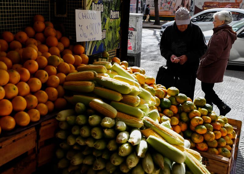 A costumer counts money before buying tangerines in a green grocery store, as Argentines struggle amid rising inflation, in Buenos Aires