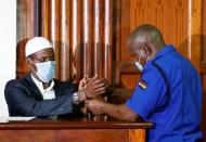 Mohamed Ahmed, a suspect charged with helping al Qaeda-linked militants to launch an attack on the Westgate mall, has his handcuffs removed as he sits in the dock during his sentencing, at the Milimani Law Courts in Nairobi