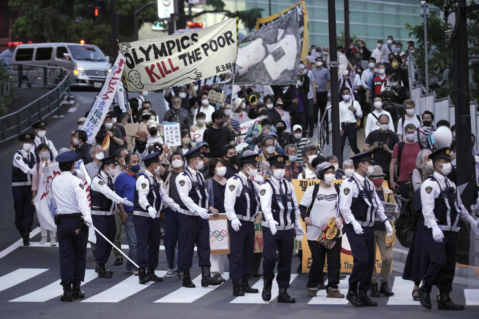 FILE - In this May 9, 2021, file photo, people against the Tokyo 2020 Olympics set to open in July, march to protest around Tokyo's National Stadium during an anti-Olympics demonstration. Polls have found an overwhelming majority of Japanese people are skeptical of the Tokyo Olympics being held this summer during a pandemic, but only a few have publicly marched to protest. But there are creative projects that are looking to protest the increasingly unpopular Tokyo Olympics, even as authorities seek to shut them down. (AP Photo/Eugene Hoshiko, File)