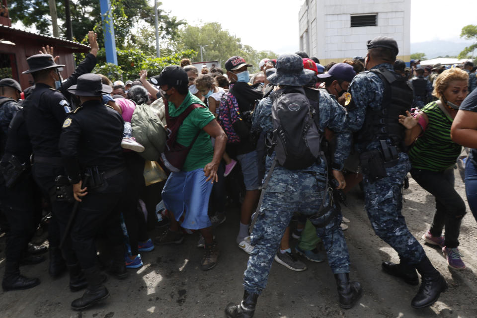 Guatemalan security forces try to keep back migrants from crossing the border from Corinto, Honduras, into Corinto, Guatemala, Thursday, Oct. 1, 2020. Hundreds of migrants walked from San Pedro Sula, Honduras to the Guatemala border, testing a well-trod migration route now in times of the new coronavirus. (AP Photo)