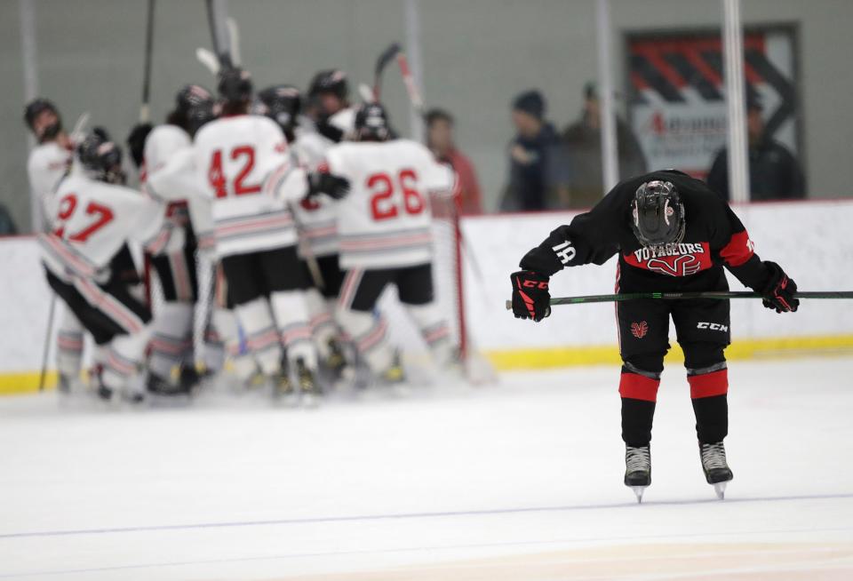 De Pere Voyageurs' Martin Blaha (18) hangs his head as Neenah/Hortonville/Menasha players celebrate their victory during their WIAA Division 1 boys hockey sectional semifinal game Tuesday, February 22, 2022, at Community First Champion Center in Grand Chute, Wis. The Neenah/Hortonville/Menasha Rockets won 5-4.Dan Powers/USA TODAY NETWORK-Wisconsin