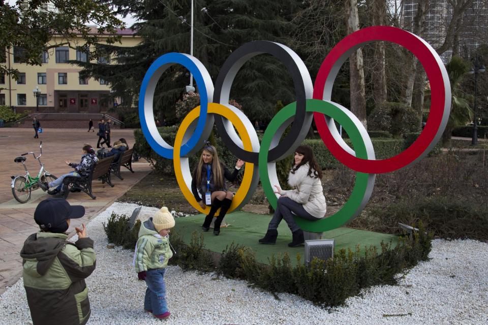 Russian women pose for snapshots next to Olympic rings in Sochi, Russia, Tuesday, Feb. 4, 2014. The opening ceremony for the 2014 Winter Olympics will be held on Feb. 7, and the competition will run until Feb. 23. (AP Photo/Bernat Armangue)