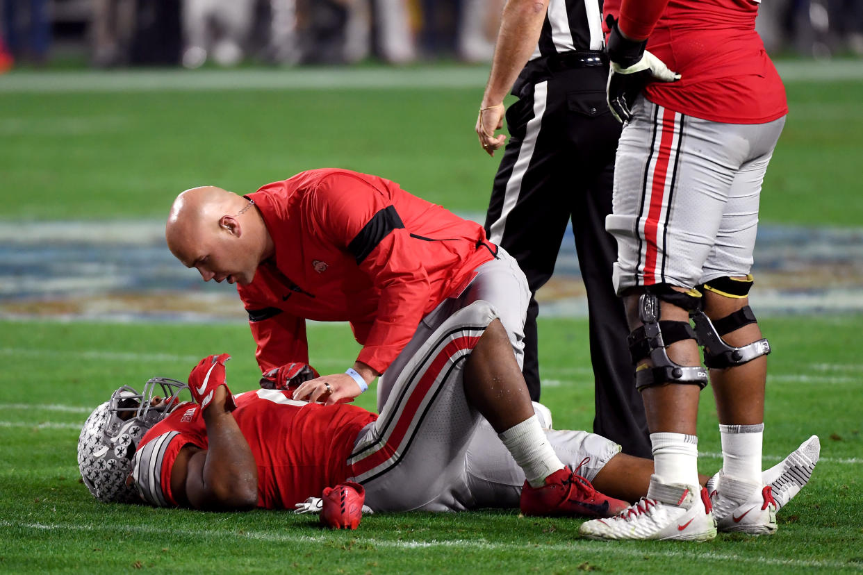 GLENDALE, ARIZONA - DECEMBER 28:  J.K. Dobbins #2 of the Ohio State Buckeyes is checked by the trainer against the Clemson Tigers in the first half during the College Football Playoff Semifinal at the PlayStation Fiesta Bowl at State Farm Stadium on December 28, 2019 in Glendale, Arizona. (Photo by Norm Hall/Getty Images)