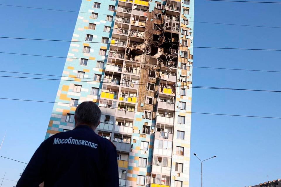 A man looks at the multi-storey residential building hit in an alleged Ukrainian drone attack in Ramenskoye (AP)