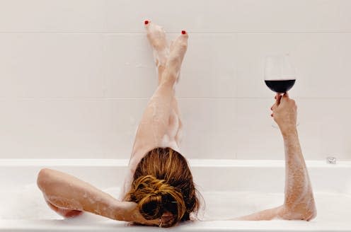 <span class="caption">There's nothing wrong with a bubble bath but there's more to wellness than pouring a glass of wine and lighting some candles. </span> <span class="attribution"><a class="link " href="https://www.shutterstock.com/image-photo/woman-holding-glass-red-wine-lying-1850507593" rel="nofollow noopener" target="_blank" data-ylk="slk:Chiociolla/Shutterstock;elm:context_link;itc:0;sec:content-canvas">Chiociolla/Shutterstock</a></span>