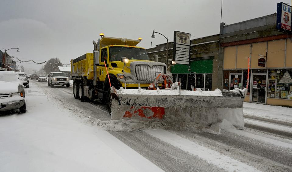 A snowplow travels down a street in Tenino, Wash., on Dec. 26.